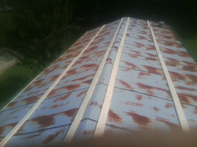Rusted metal roof panels with new wood purlins before replacement — Storm Damage Roof Repair in Appleton by Roofing Brothers