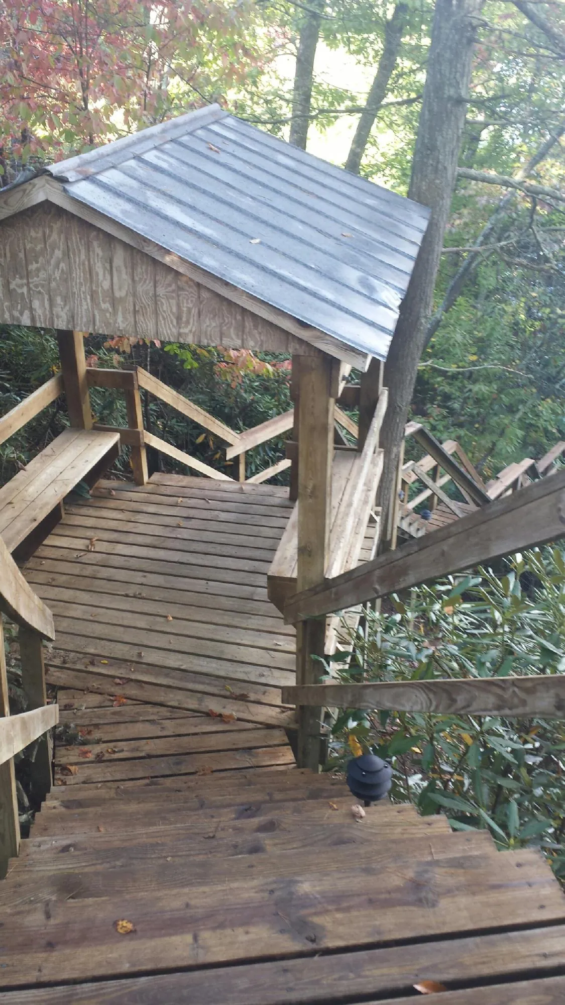 Metal roofed shelter over wooden steps on a wooded walkway — Skylight Repair & Installation work by our crew in Appleton