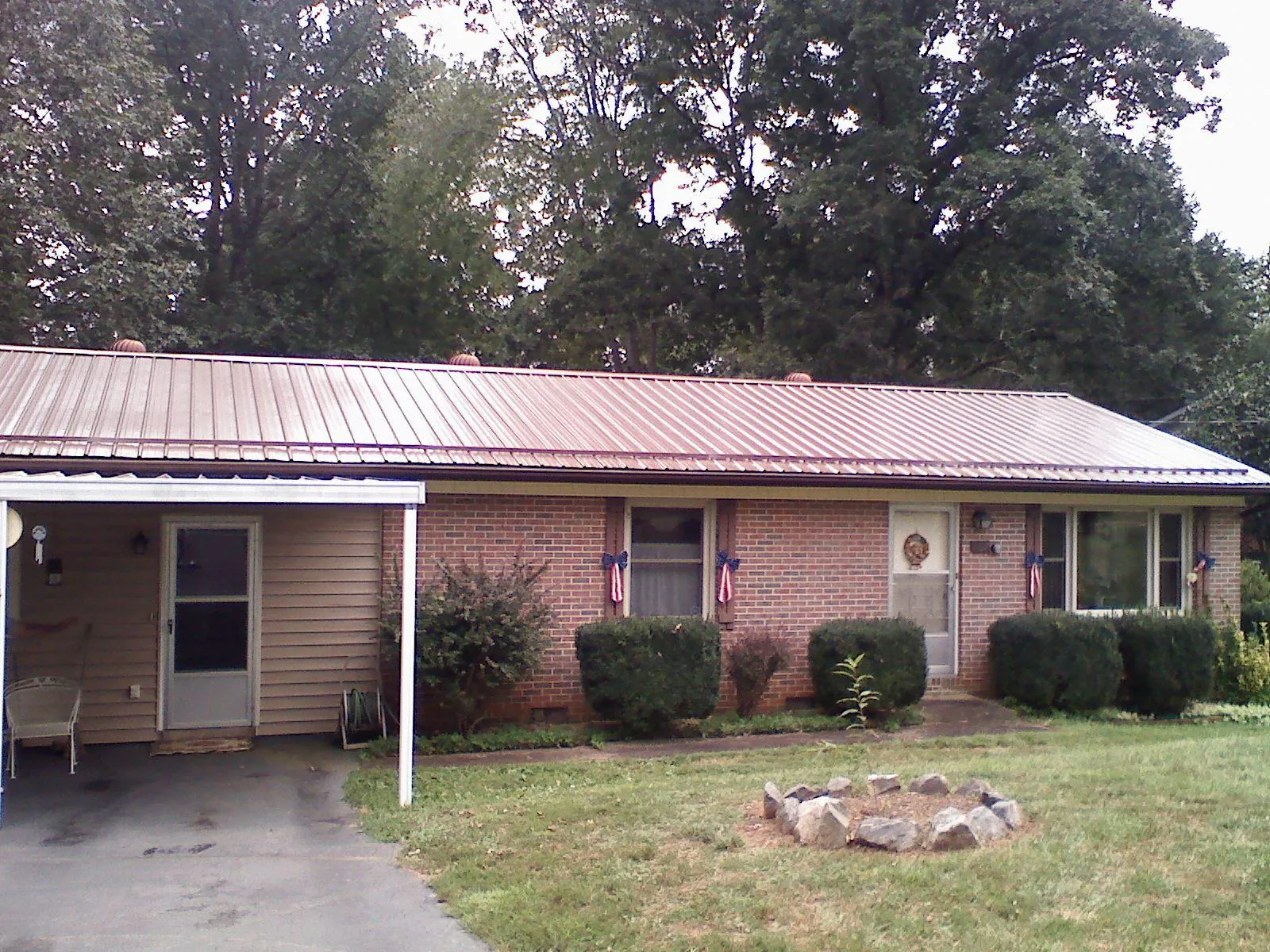 Bronze metal roof and carport on a brick ranch home — Roof Repair work by our crew in Appleton